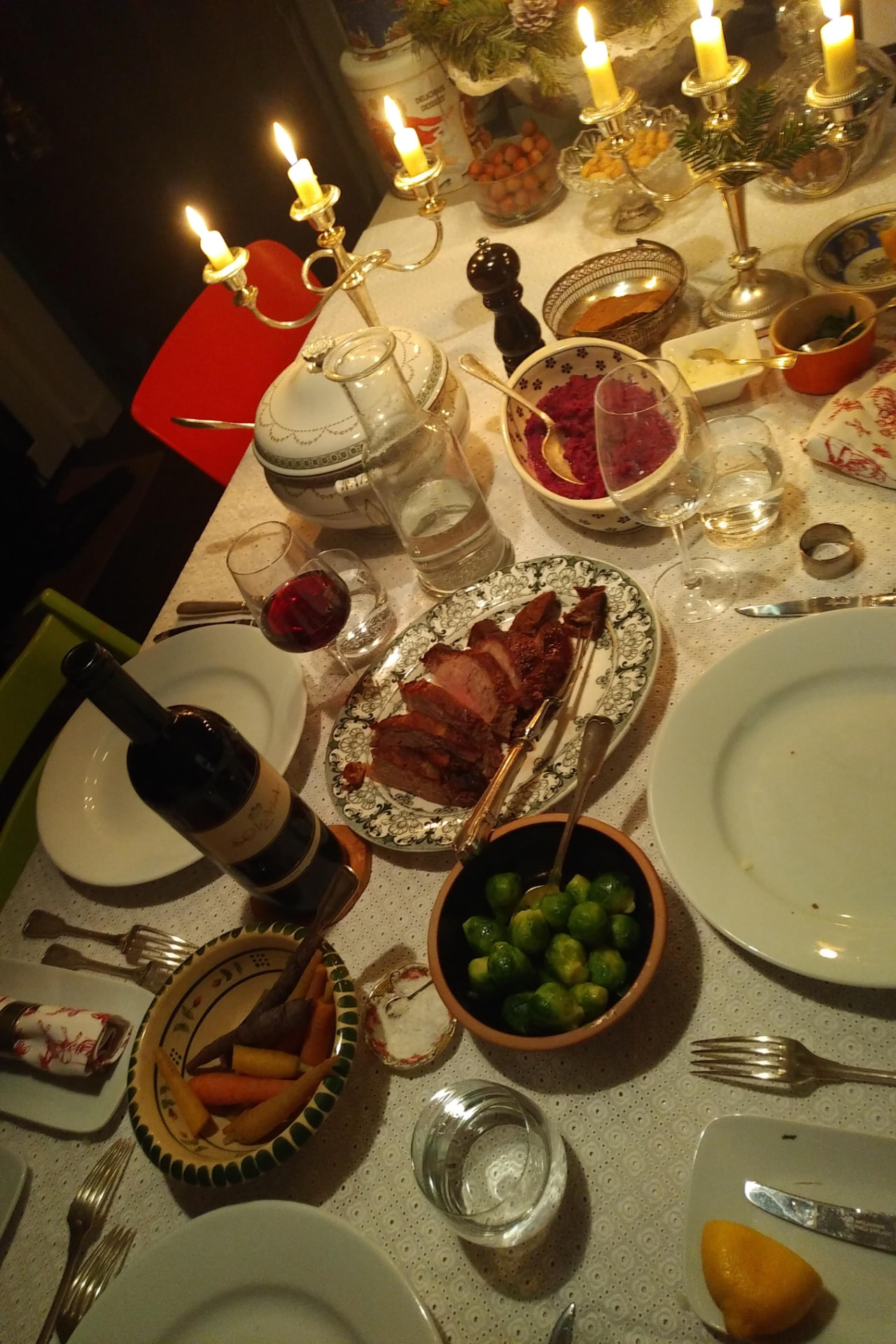 A candlelit winter table with roast, sprouts and red cabbage