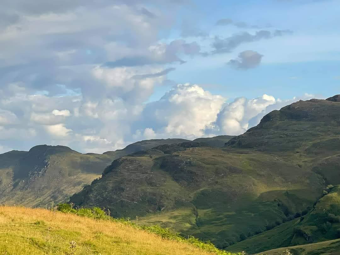 Green Scottish hills opening towards a distant loch