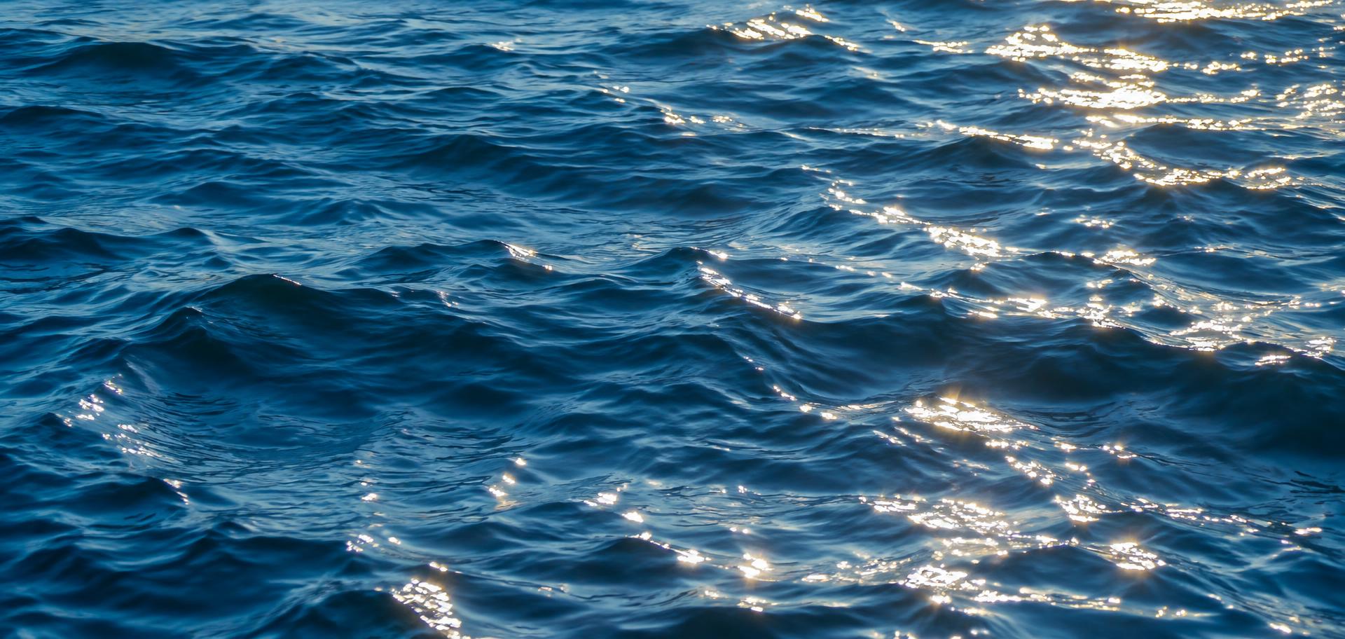 Open blue water beneath a mountain horizon